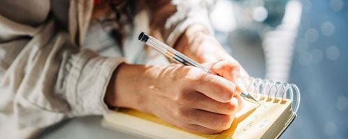 A woman writing her to-do list