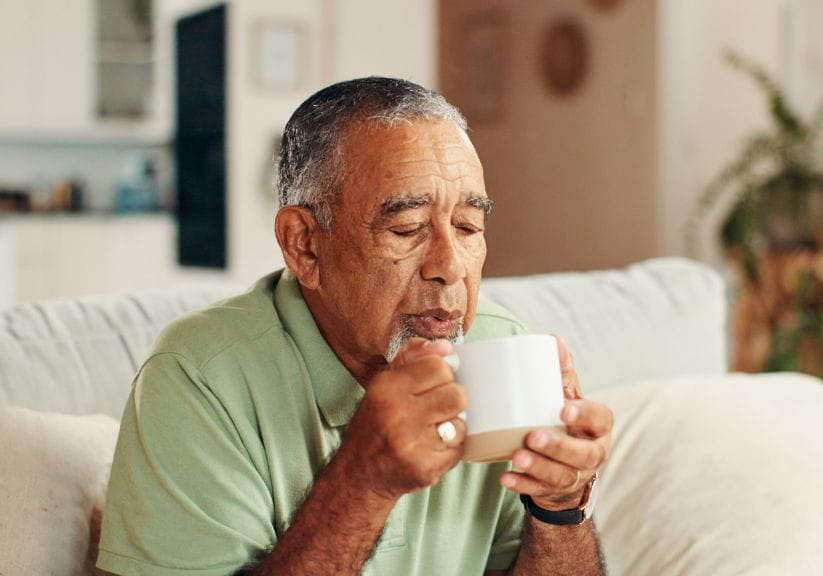 Man blowing on a hot drink