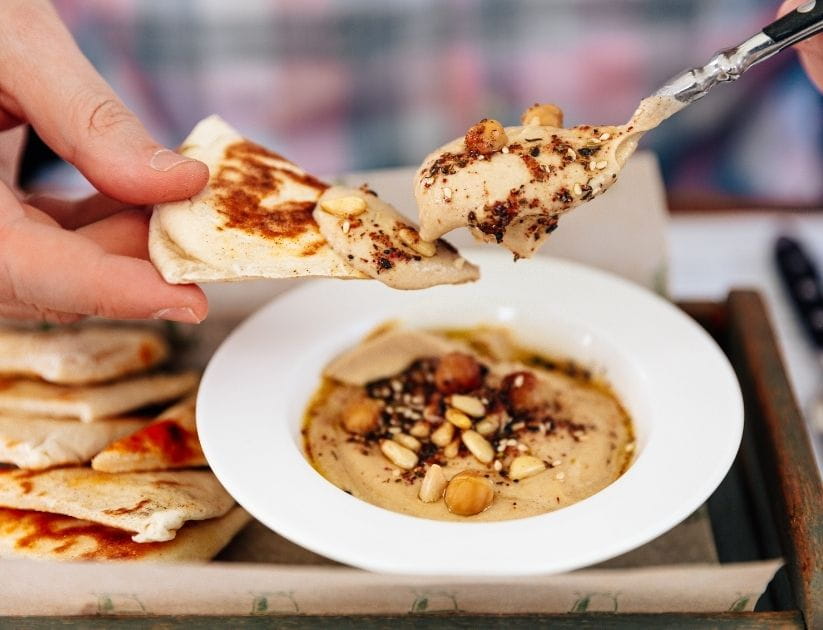  Man eating hummus with pita bread, close-up