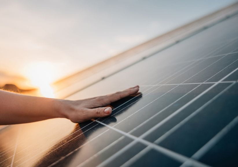 Someone attaching solar panels to the roof
