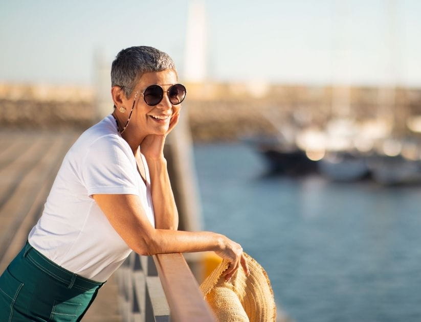 A woman on holiday wearing sunglasses as she relaxes and enjoys the sun