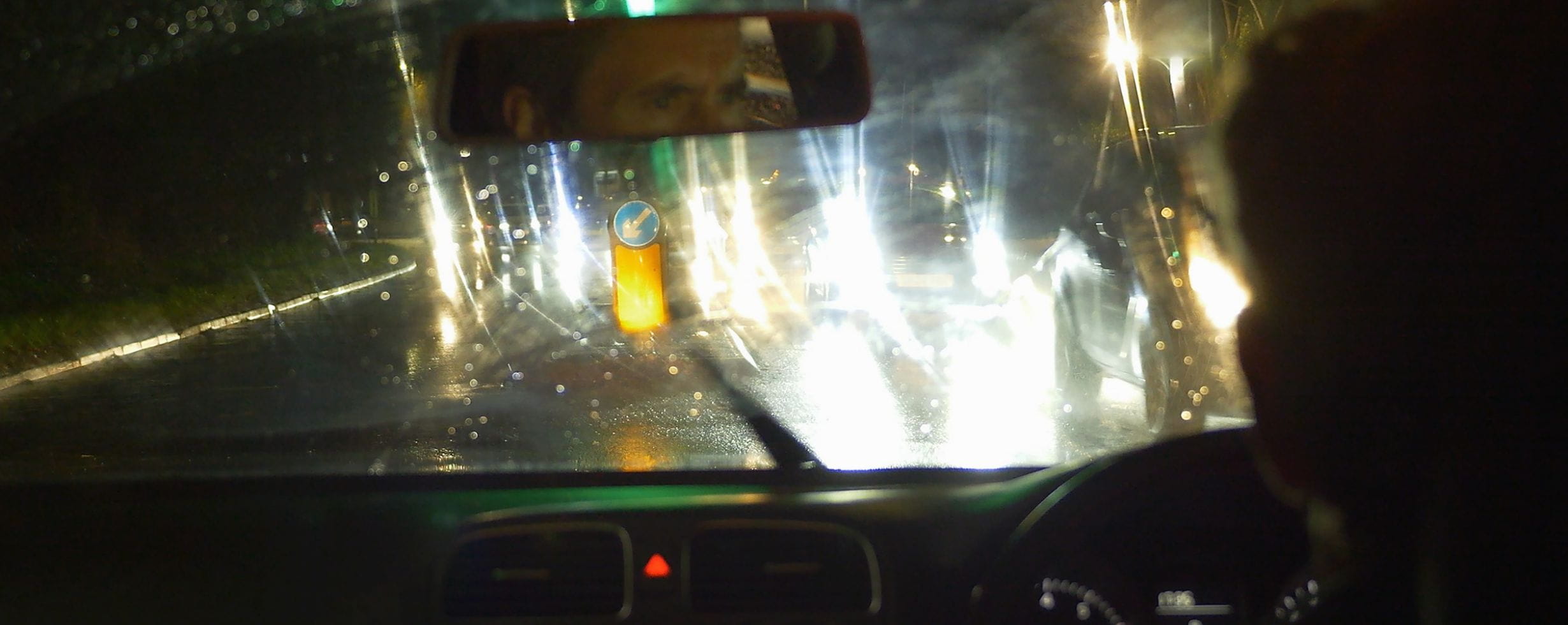 A man is dazzled by headlights on the road