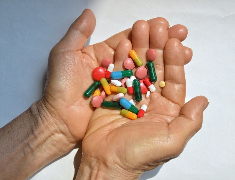 Hands holding different types of pills together