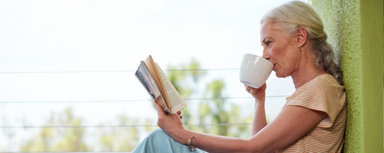 Woman reading outdoor with a cup of tea