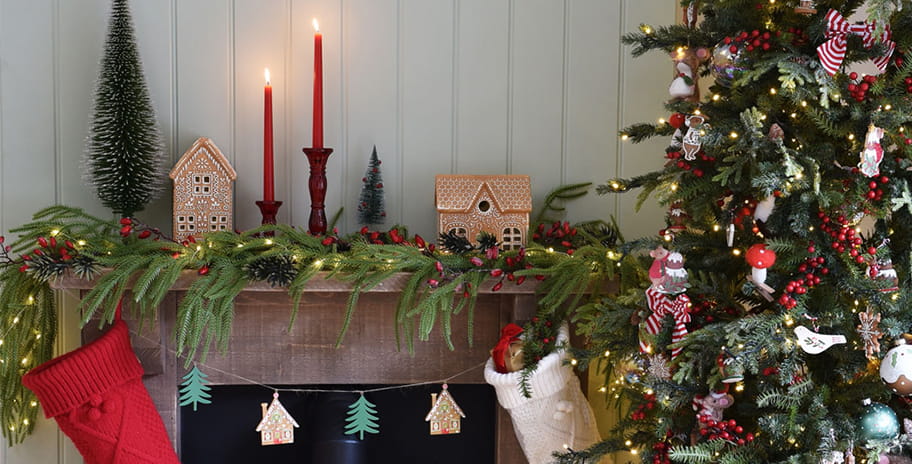 A Christmas tree and decorations over a fireplace