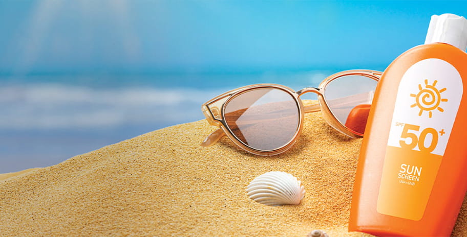 Suntan lotion or sun cream on the beach sand on a sunny day