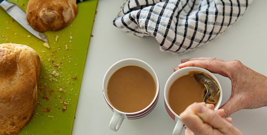 An older persons hands making a cup of tea