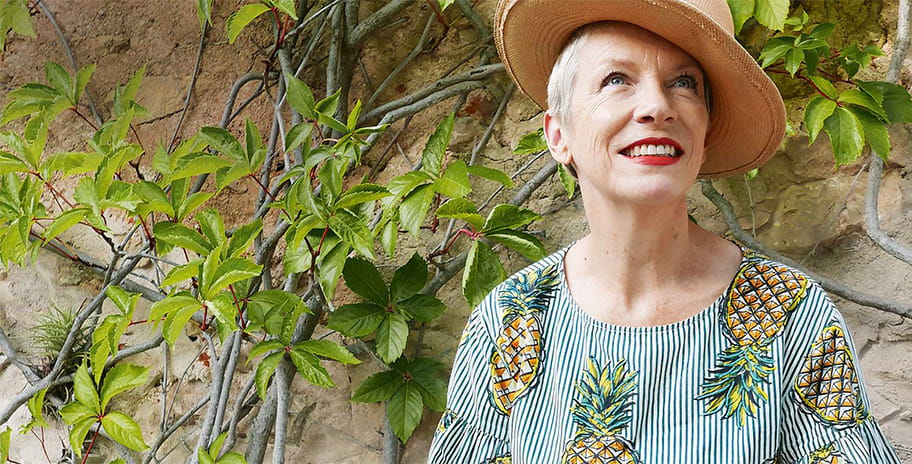 Annie Lennox wearing a hat and a flowery shirt