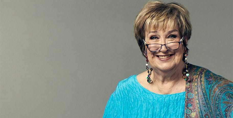 Dame Jenni Murray in front of a grey background