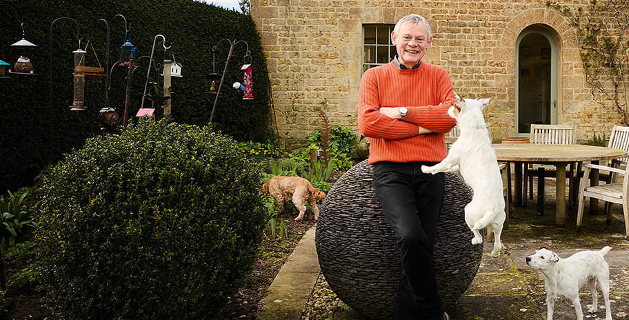 Martin Clunes in his garden with his dogs John and Murray
