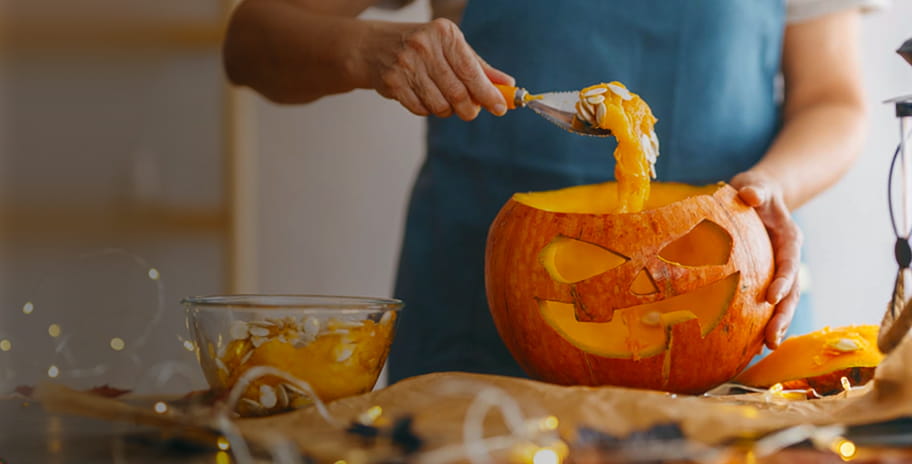A woman carving a pumpkin