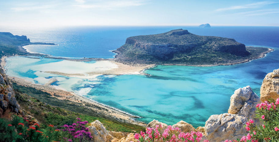 Balos Beach, located on the northwestern tip of Crete near Kissamos, is famous for its striking lagoon of turquoise waters, soft white and pink-tinged sand, and dramatic surrounding cliffs
