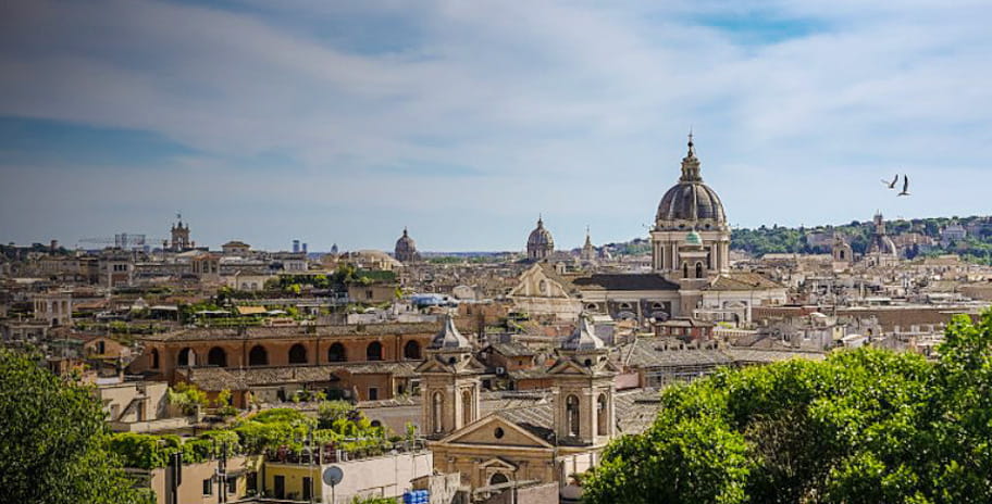 A picture of the city of Rome with a nice view of the buildings and a blue sky