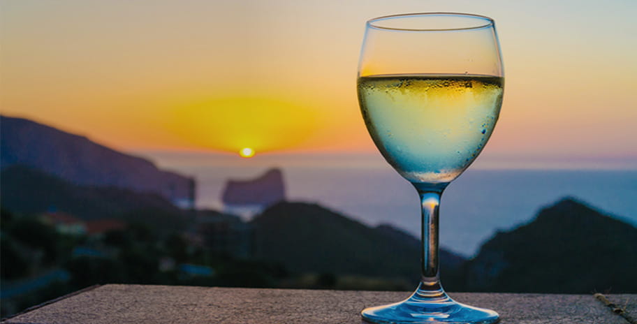 Image of a wine glass on a wooden table, with a beautiful evening background