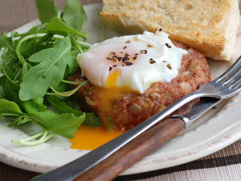 corned beef hash cakes with cheesy topping and a poached egg