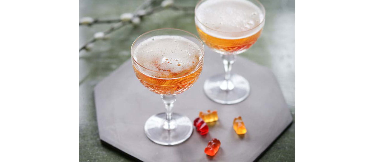 Two glasses of champagne with Haribo bears next to them