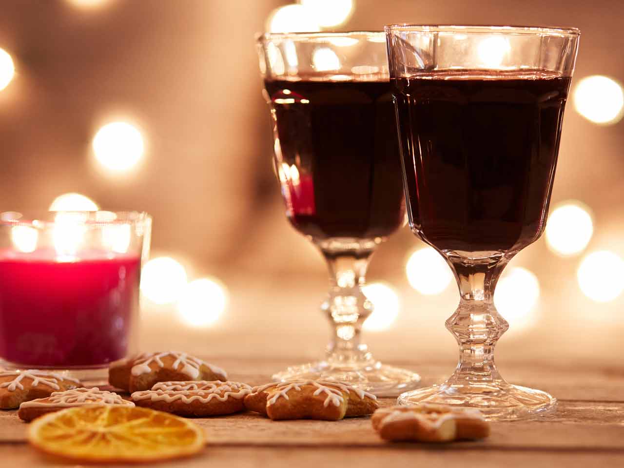 Glasses of Glogg beside festive cookies and candles