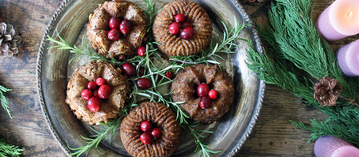 Five small bundt chestnut nut roasts garnished with rosemary and berries