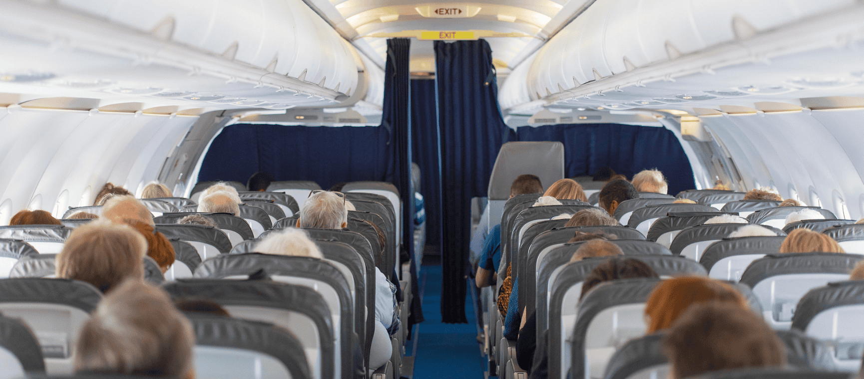 a view from the back of a commercial flight of the passenger cabin