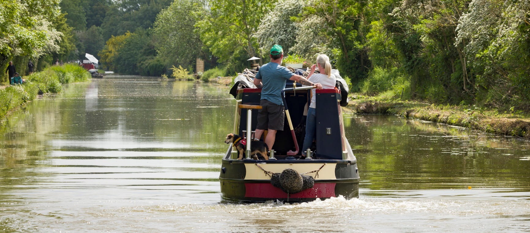 Man and woman steer a narrowboat