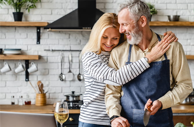 Two people hugging and smiling in a kitchen