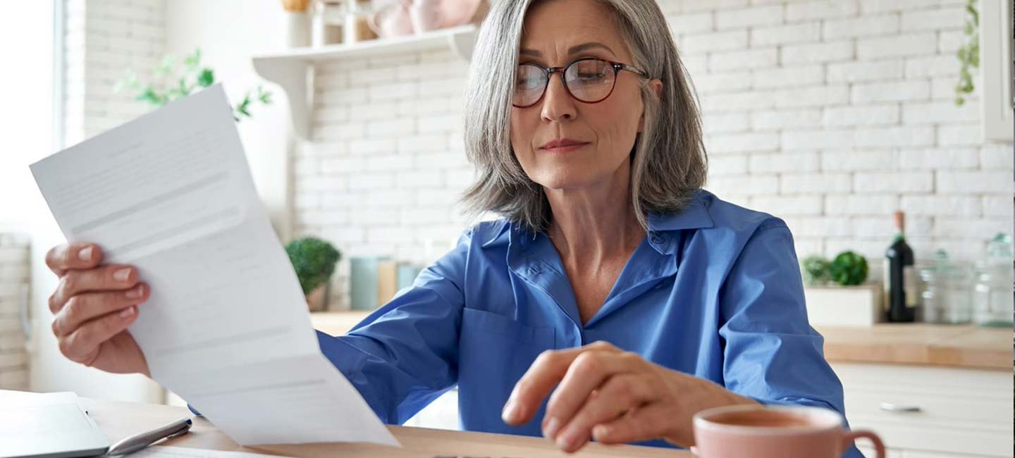 Woman in kitchen looking through paperwork
