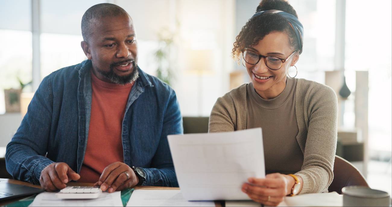 Mature couple sitting on a table looking at a contract 