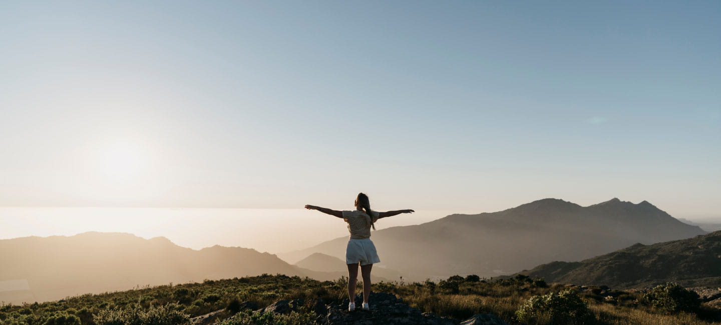 A woman looking across at a mountain range