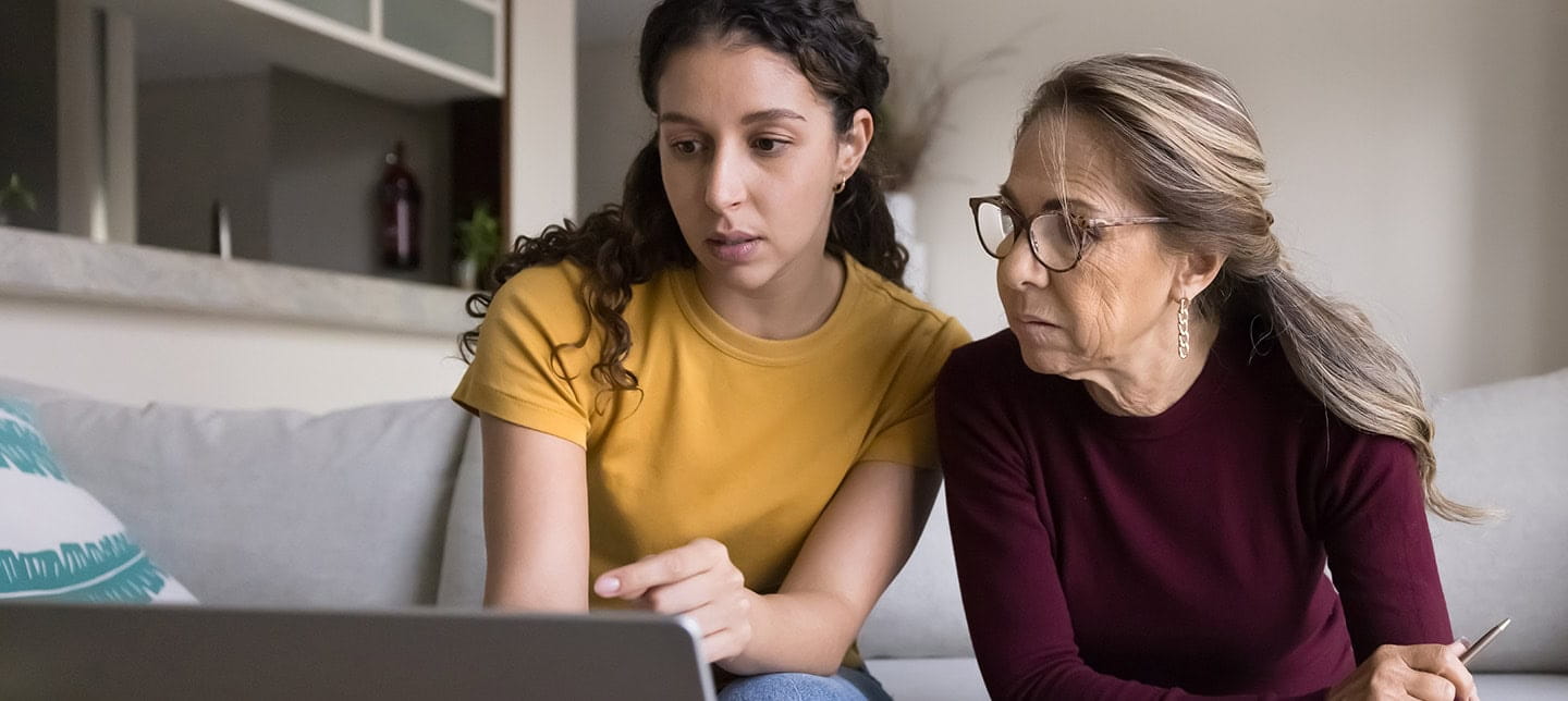 A mother and daughter using a laptop and dealing with paperwork