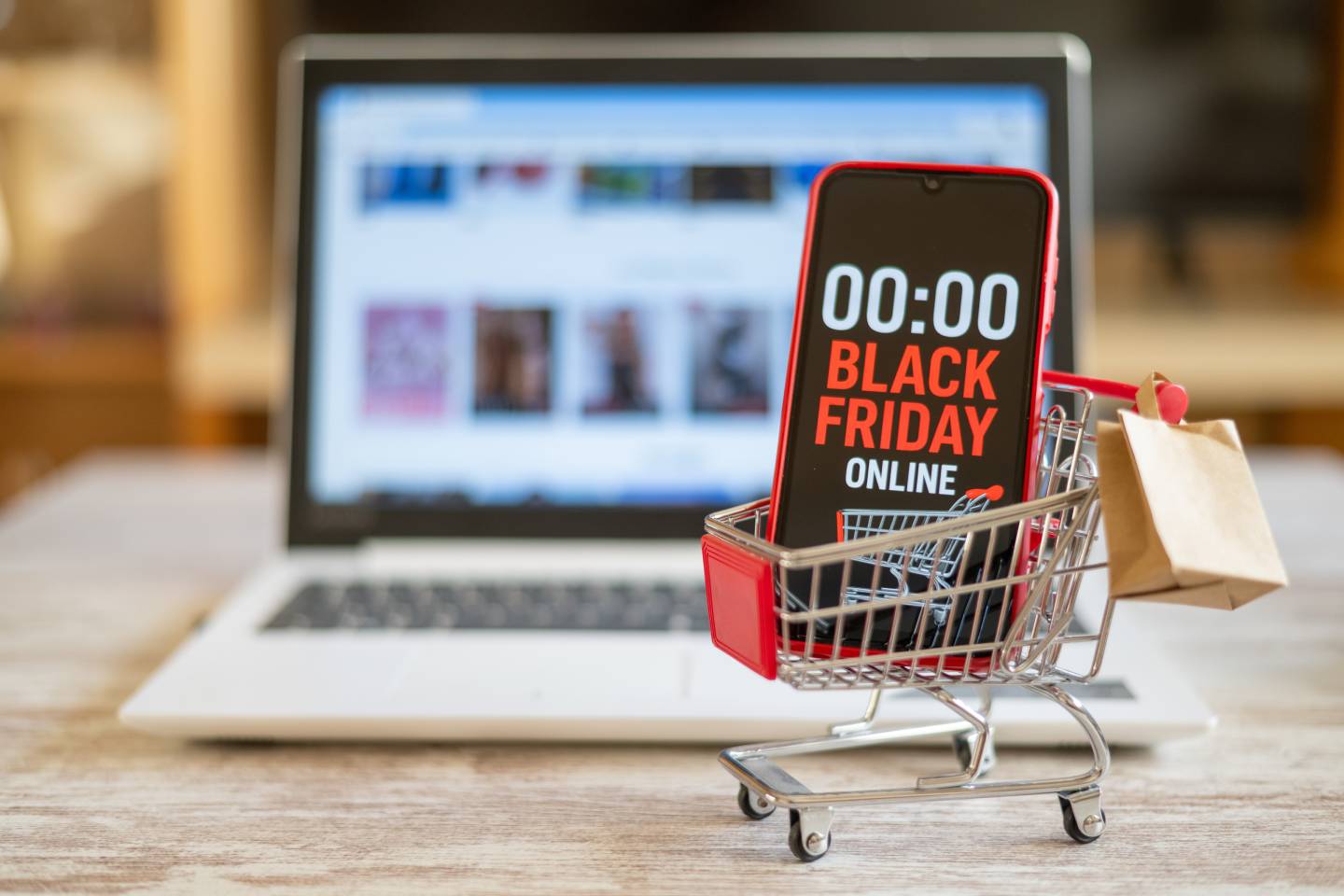 Shopping cart with smartphone showing black friday online countdown and small shopping bag
