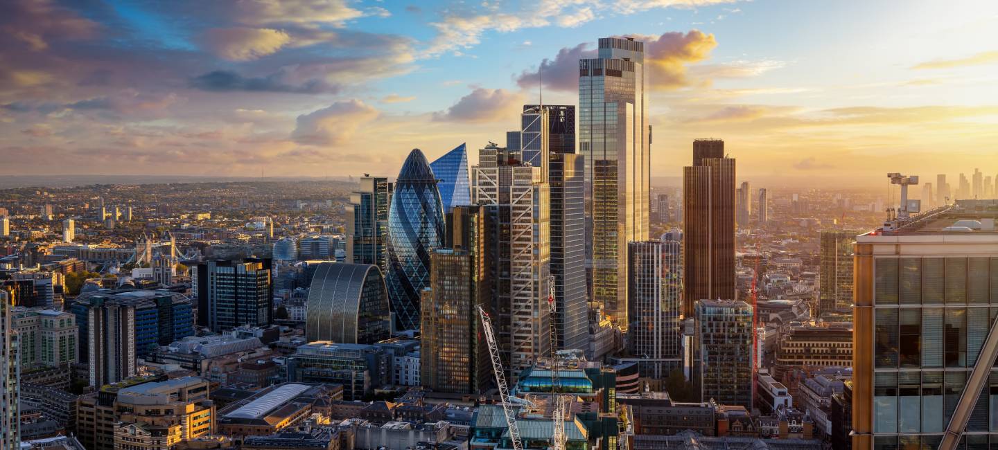 Elevated view of the City of London with the financial skyscrapers and Tower Bridge in the background during golden sunset time