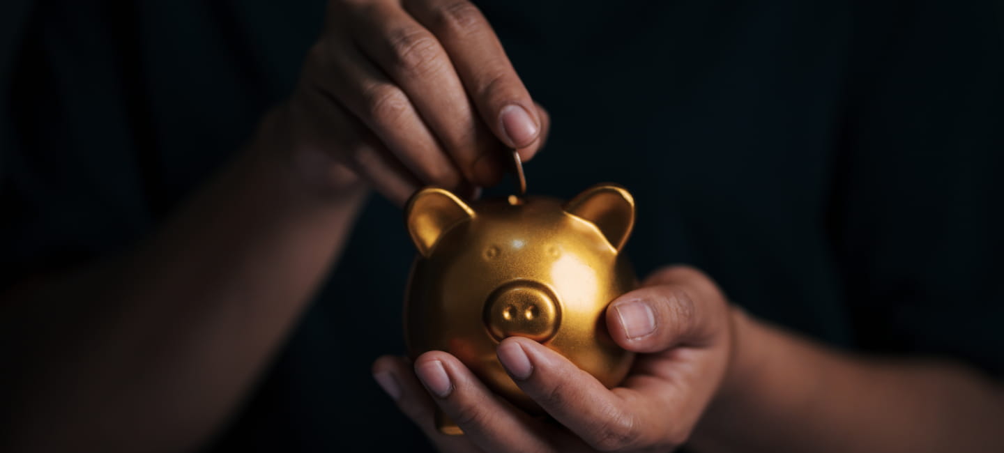 Man placing coin in piggy bank