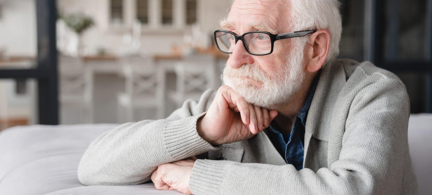 Man looking glum with his chin resting on his hand