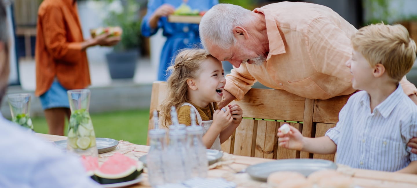 Smiley grandfather hugging his grandkids 