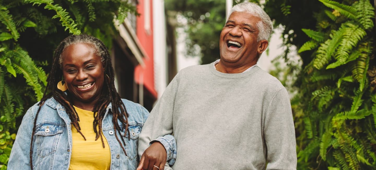 A couple laughing and linking arms 
