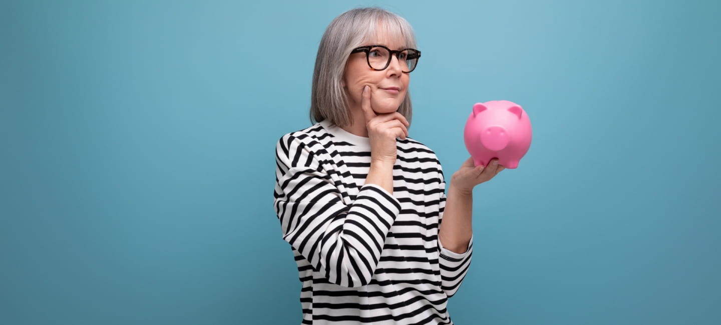 A woman holding a pink piggy bank