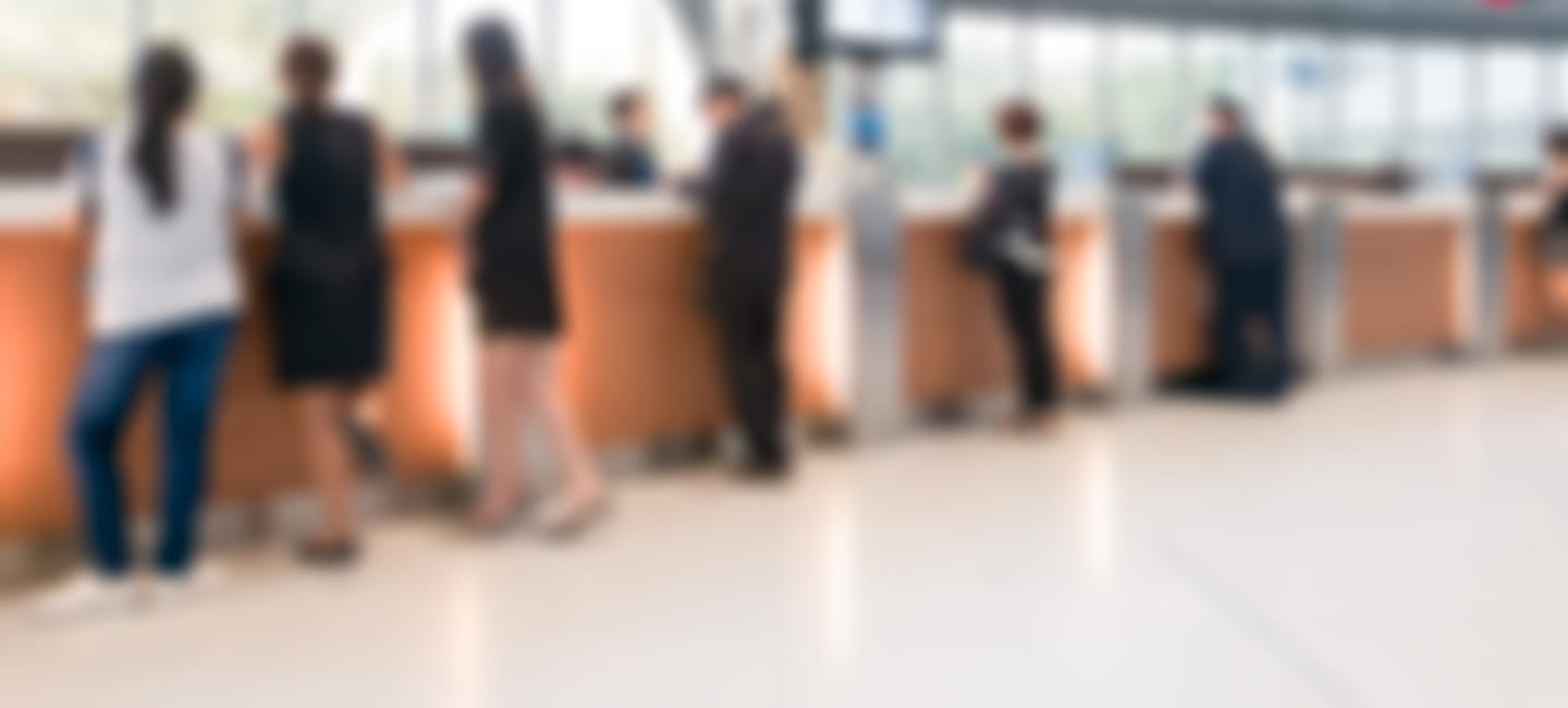 People standing at counters at a banking hub