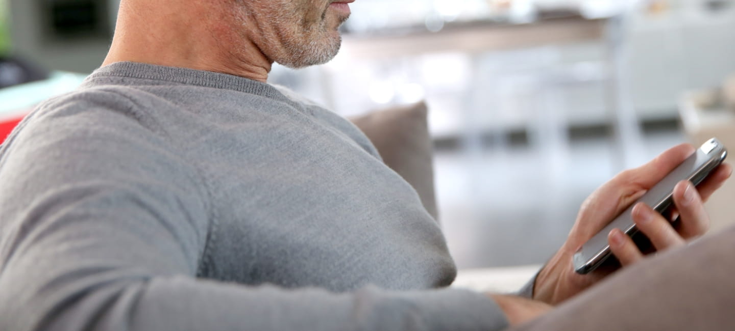 A man looking at his phone in his hand