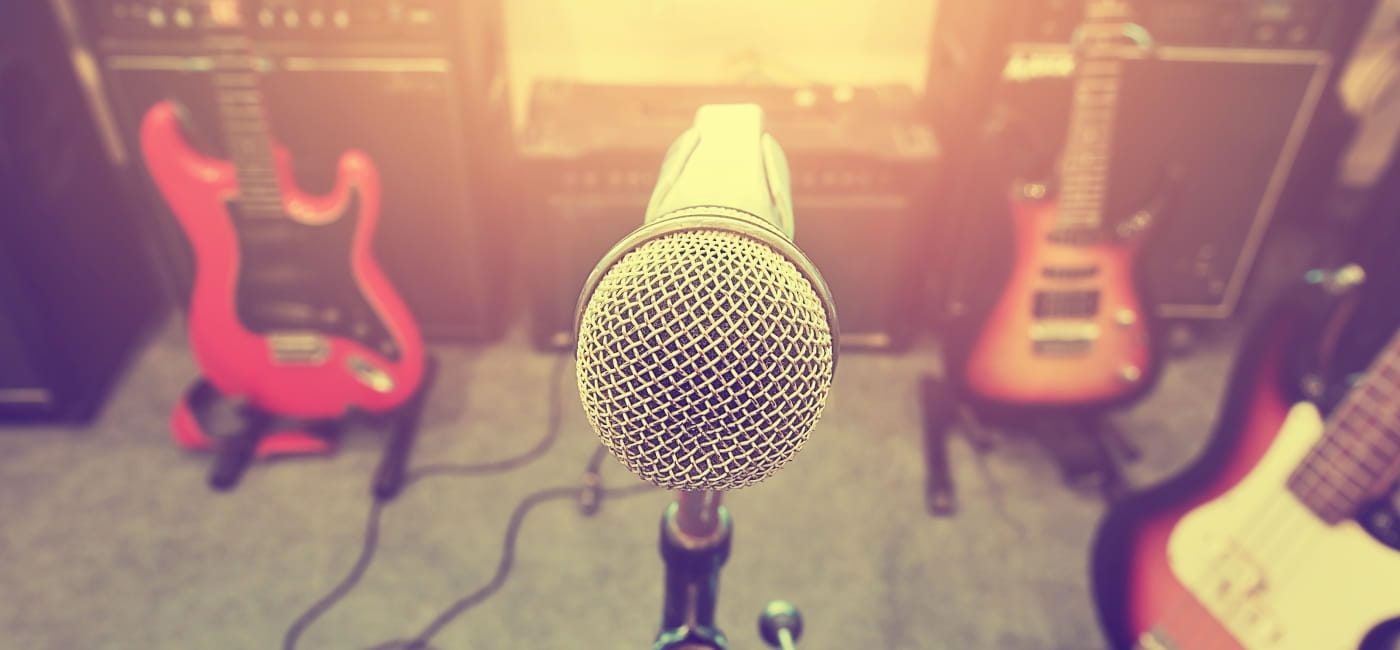 A microphone and three guitars