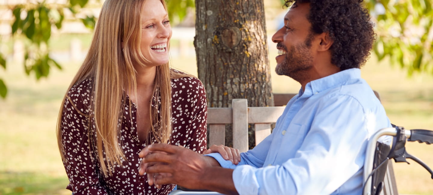 A smiley couple sat in a park