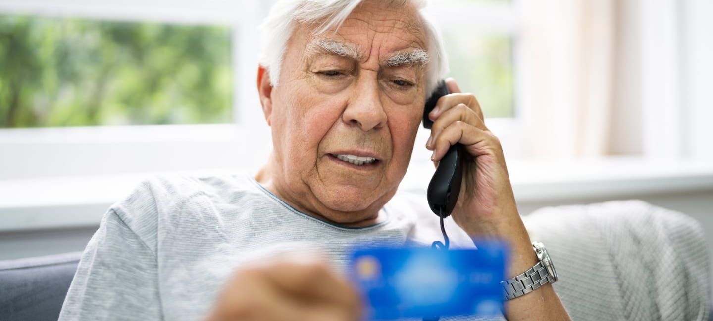 A man sat on the sofa on the phone