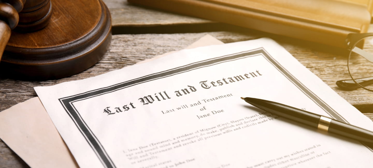 Last Will and Testament, pen and gavel on wooden table, closeup.