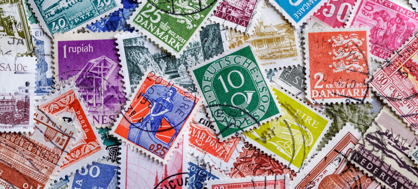 Postage stamps.A collection of world stamps in a pile.Postage stamps from different countries and times