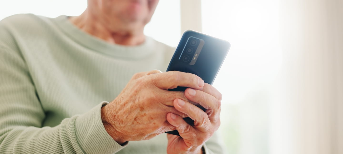 Home, closeup and senior hands with a cellphone, typing and connection with social media, digital app and contact. Old man, pensioner or mature guy with a smartphone, mobile user and search internet