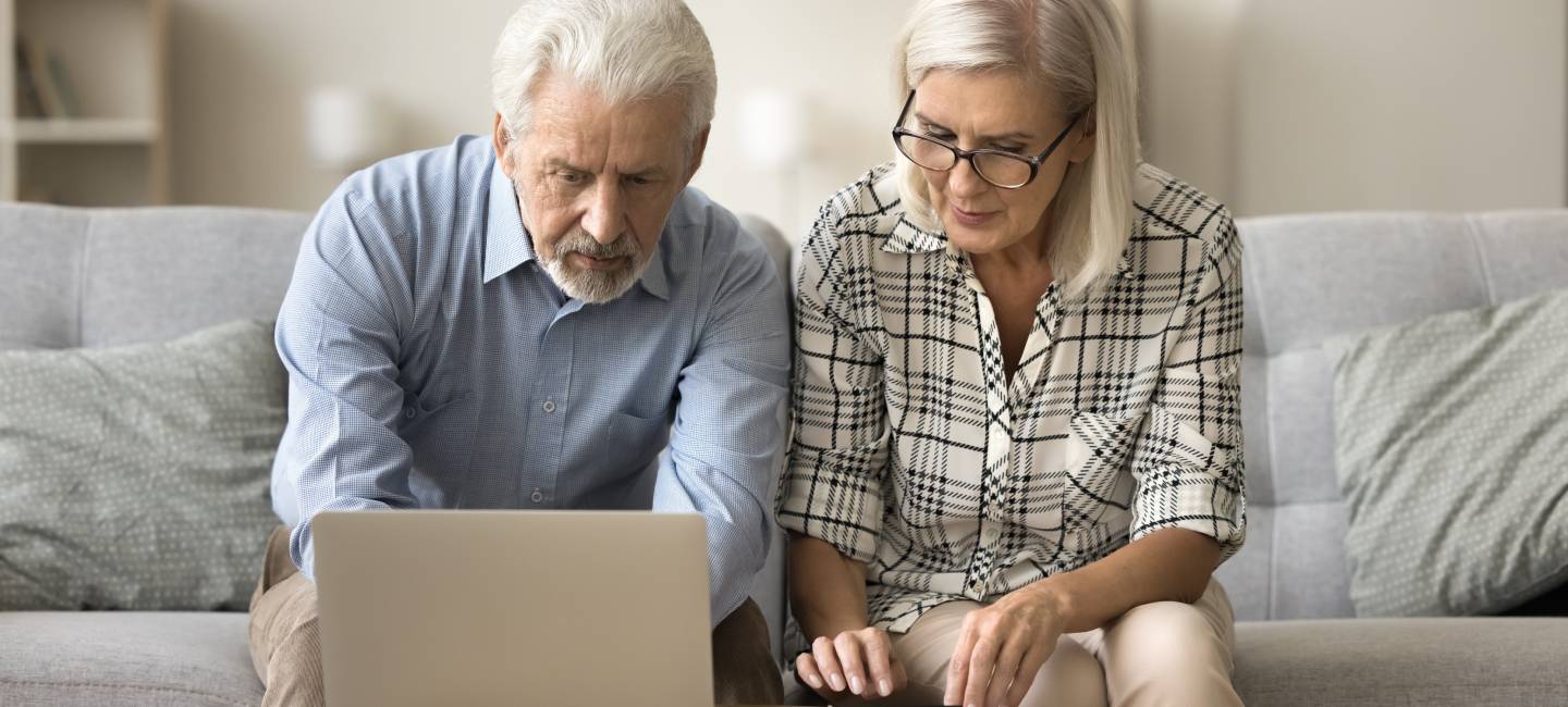Couple sitting on the sofa going through finances
