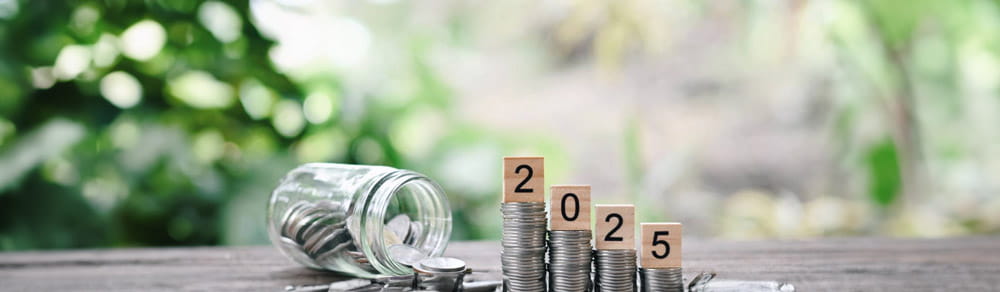 tack of coin and 2025 wooden text block and glass bottle on table, happy new year