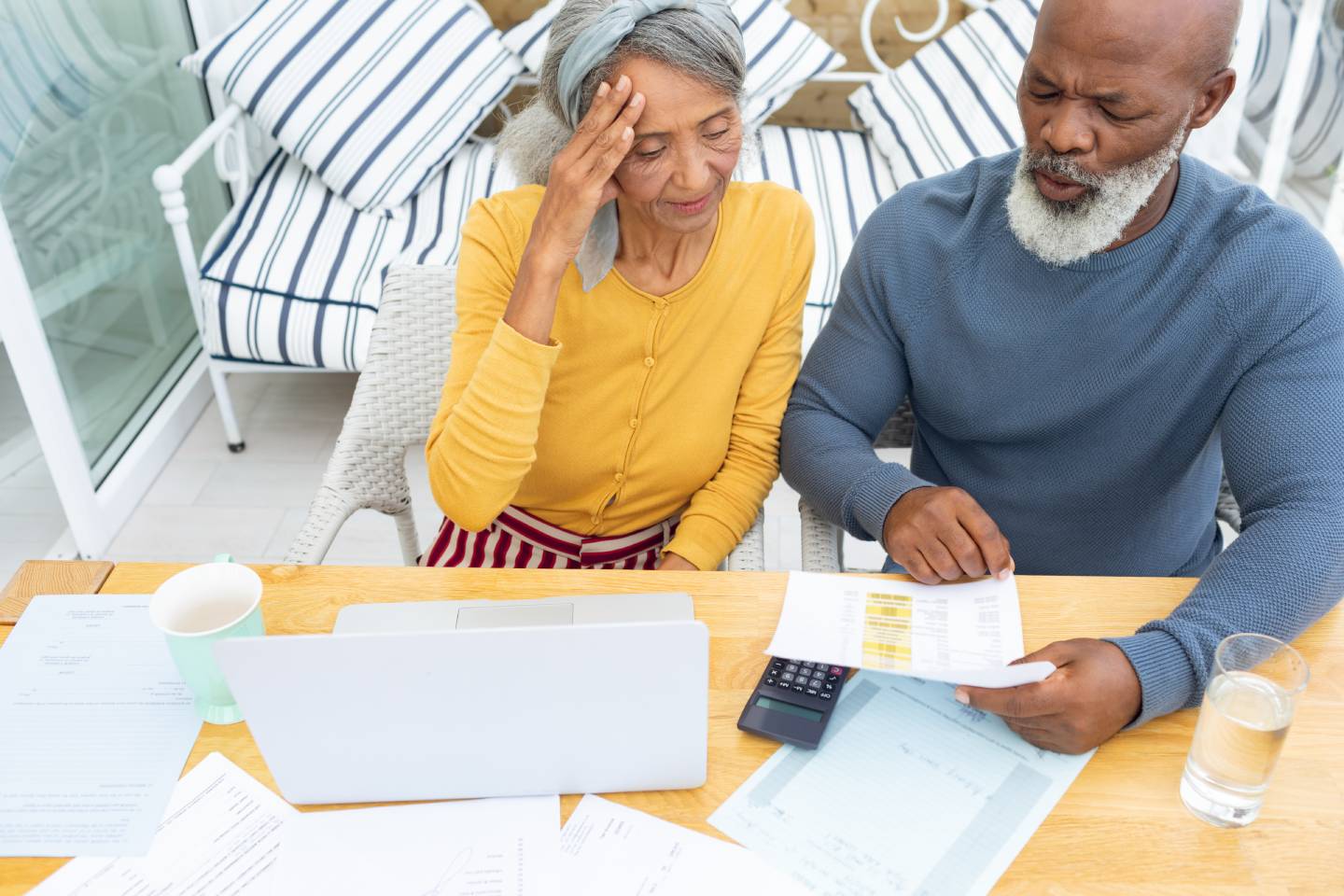 Focused senior couple on a laptop and looking at statements