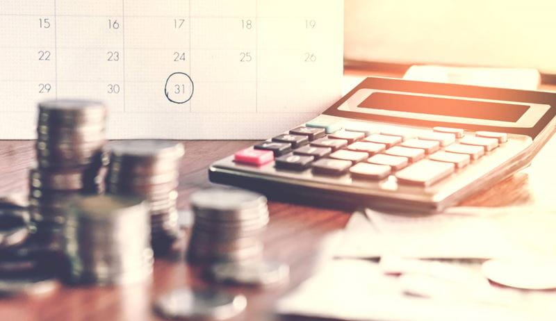 debt collection and tax season concept with deadline calendar remind note,coins,banks,calculator on table, background ,time to pay concept