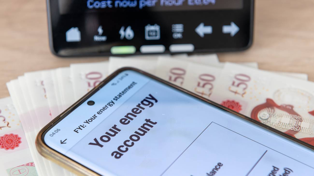 A digital bill on a mobile phone, a smart energy meter and bank notes.