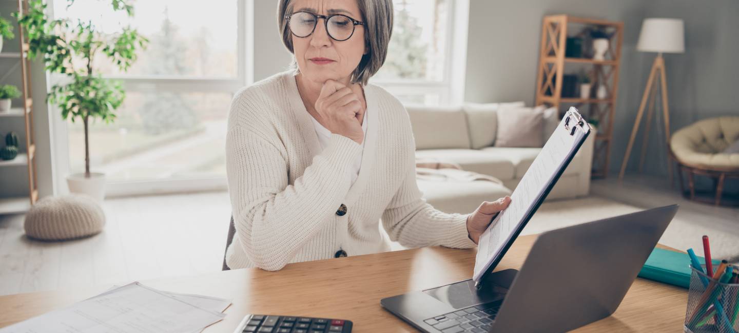 Photo of senior lady dressed white cardigan counting payment modern gadget indoors house room